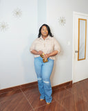 Plus size model wearing blue button down pleated back shirt with denim shorts front view