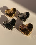 Gold and silver sculpted heart statement stud earrings with ribbed textured design
