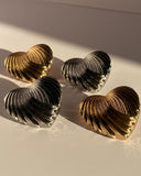 Gold and silver sculpted heart statement stud earrings with ribbed textured design