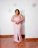 Plus size model wearing the LYSAIRE Rosé Royale dusty pink pearl embellished formal maxi dress, featuring a sparkling rhinestone and pearl-adorned square neckline, delicate shoulder straps, fitted waist, flowing floor-length skirt, and elegant front thigh-high slit, styled with metallic gold heels.