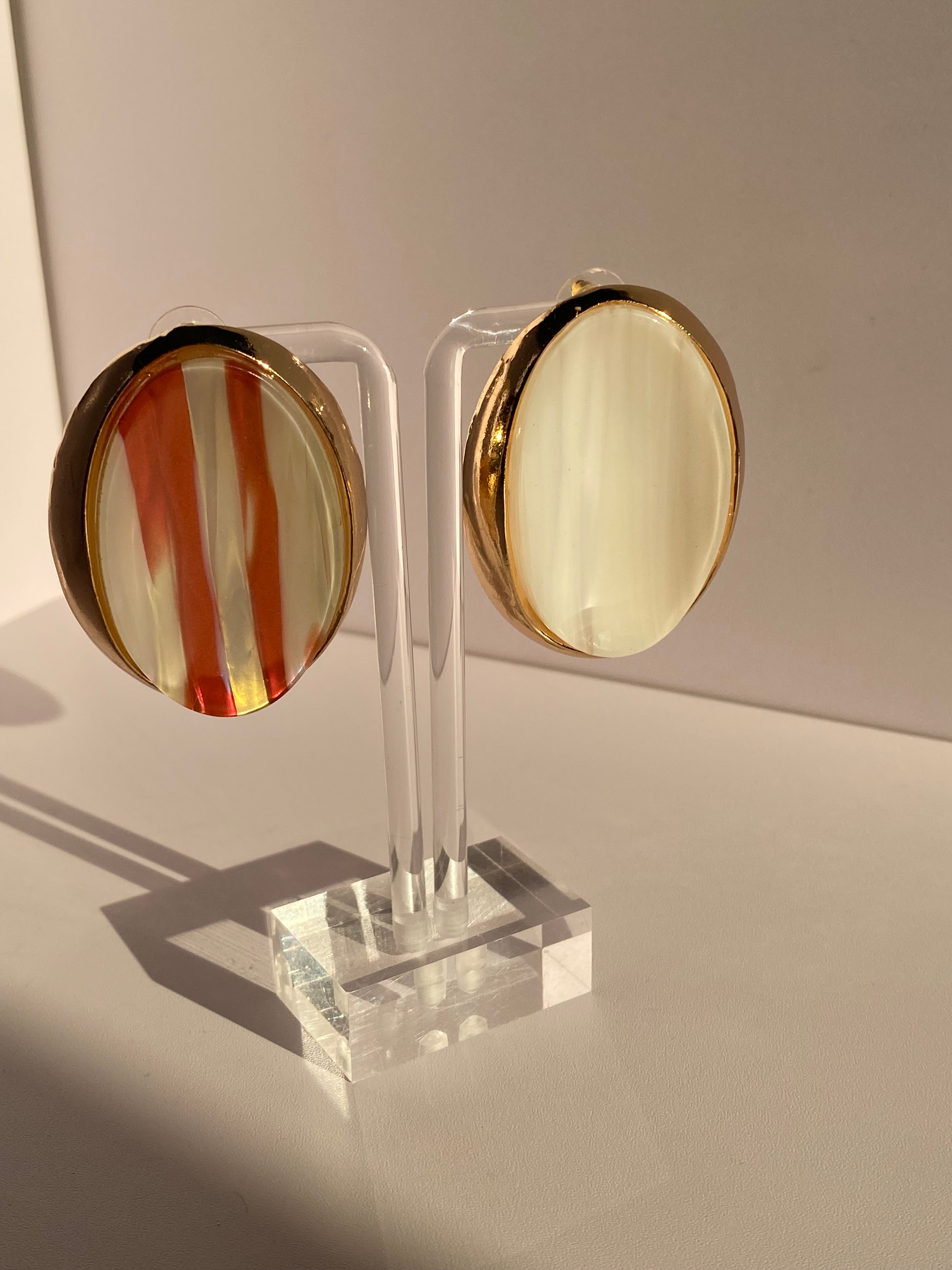 Vintage-inspired oval statement stud earrings with glossy amber orange and cream striped centers and gold-tone borders