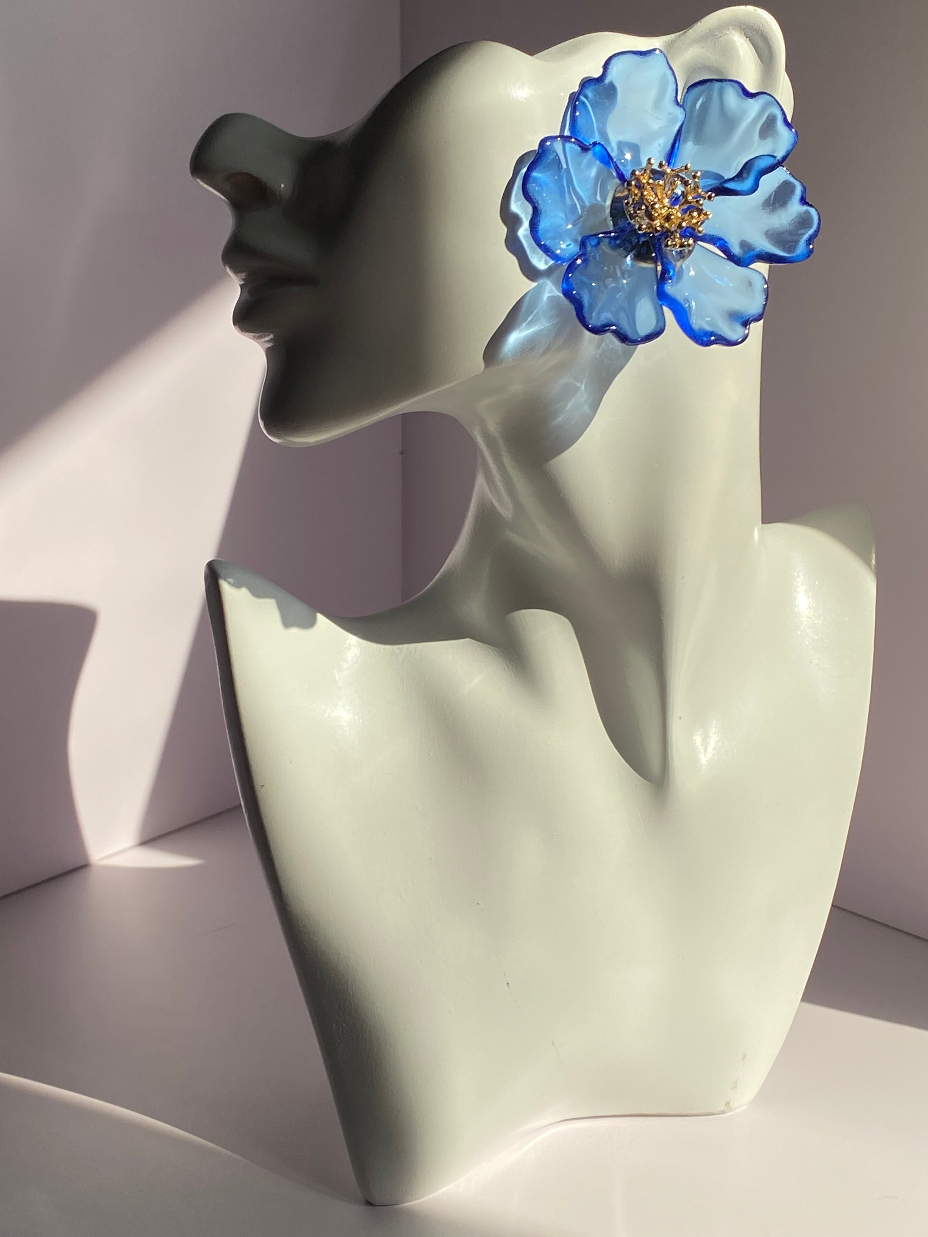Oversized royal blue floral statement earring with transparent blue petals and gold-tone flower center