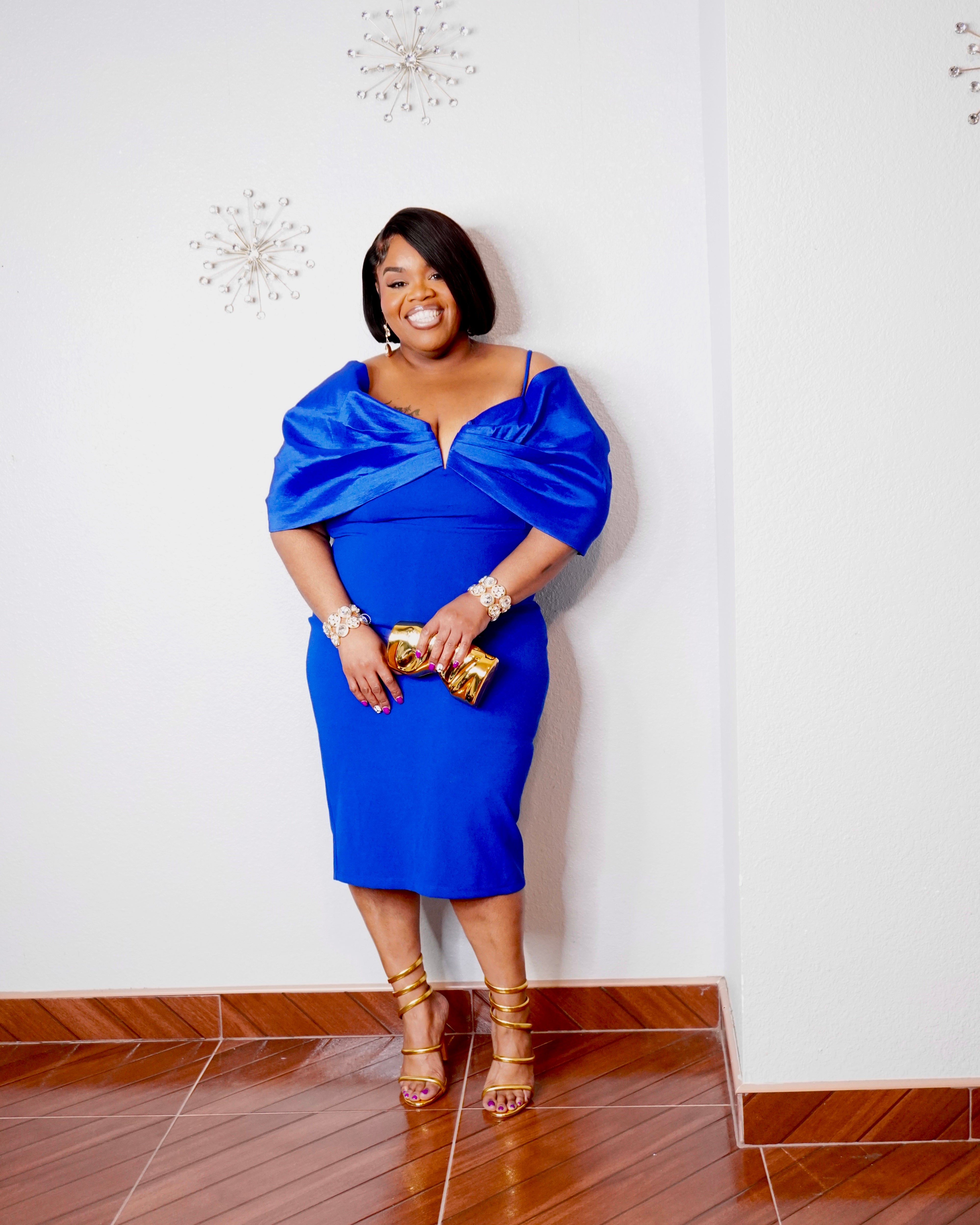 Back view of royal blue plus size midi dress showing adjustable shoulder straps, center-back zipper, fitted silhouette and rear slit.