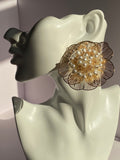 Oversized gold floral statement earring with intricate openwork petals and ivory pearl-like bead cluster from LYSAIRE